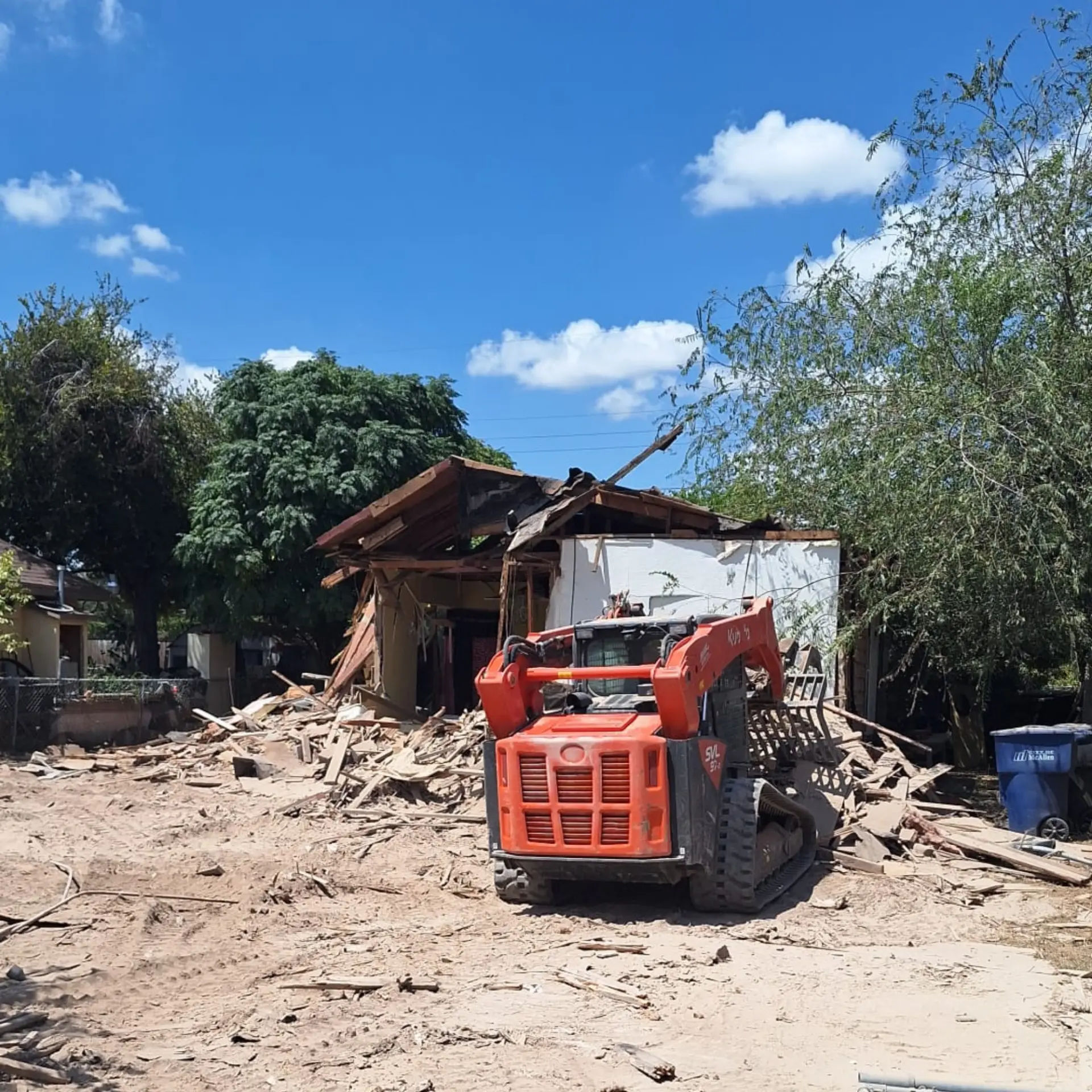 J&J Building Solutions track loader clearing a demolished house site in the Rio Grande Valley