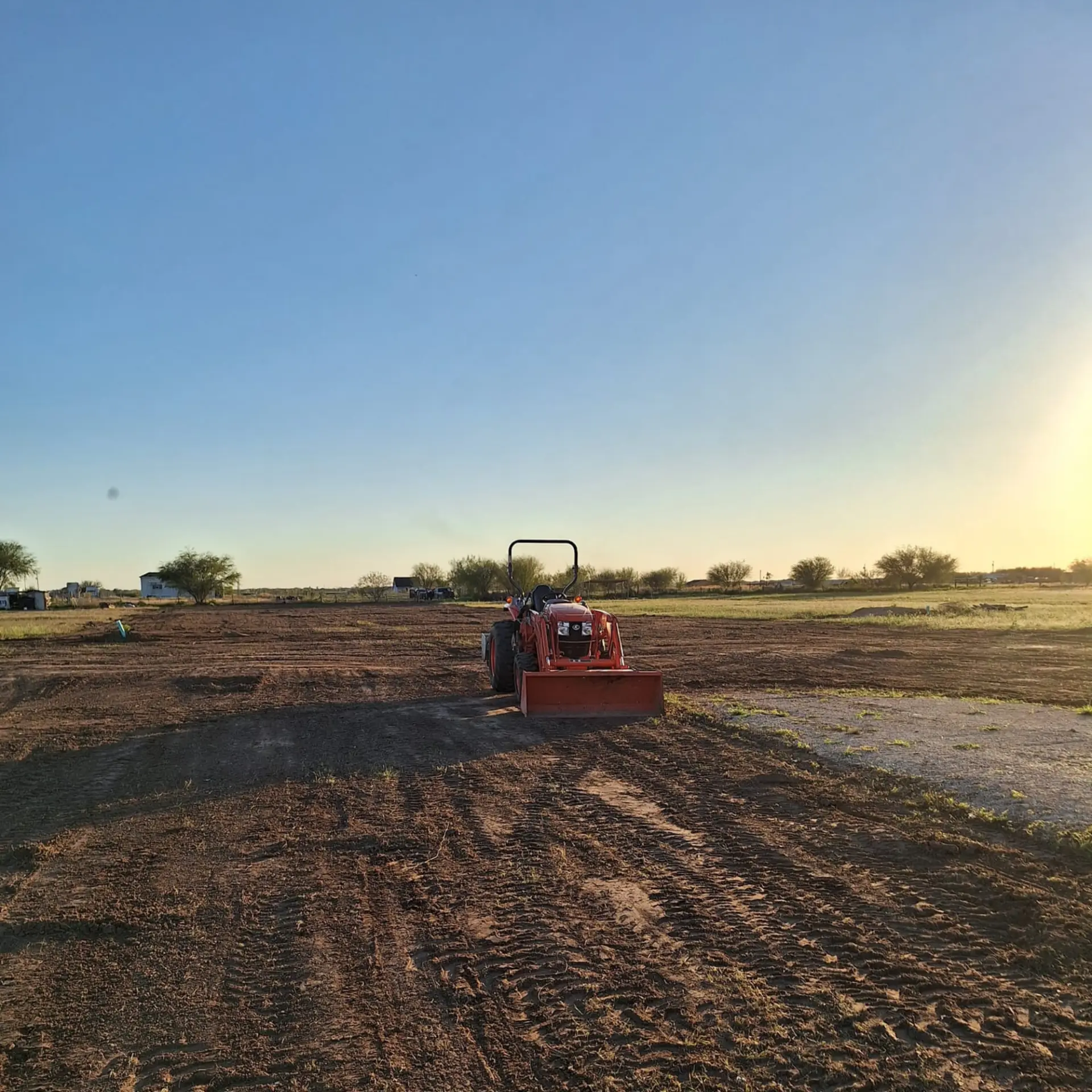 Tractor leveling dirt for a caliche driveway and access road
