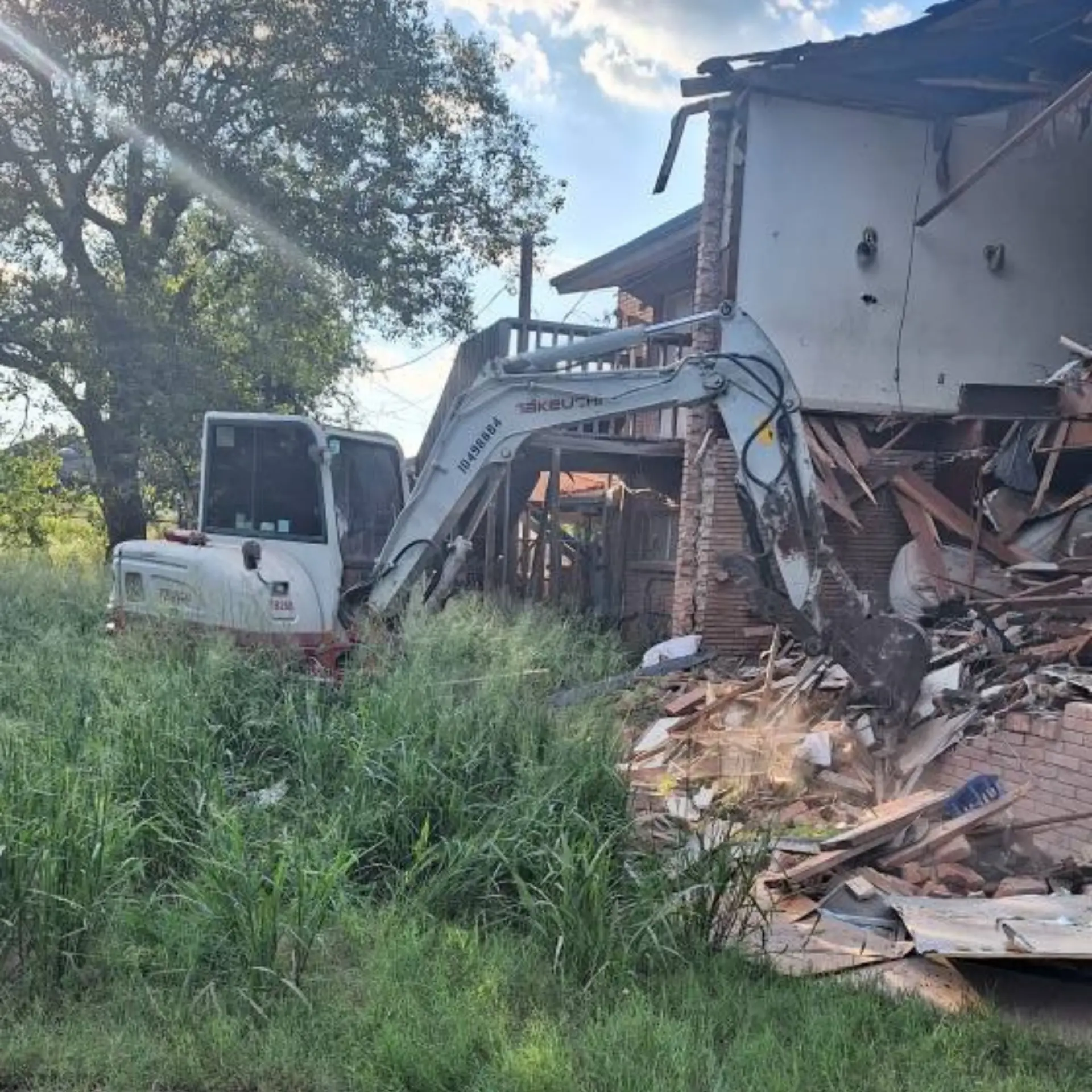 Excavator demolishing a two-story brick building